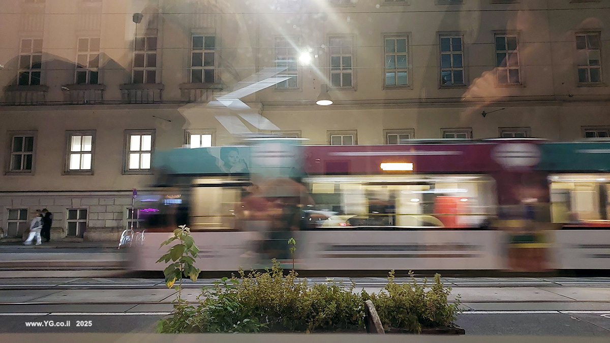 טשטוש תנועה; הבניין ברקע חד, הצמח בחזית חד ואילו תנועת החשמלית "מרוחה" עקב תנועתה. צולם מחלון של מסעדה איטלקית בוינה