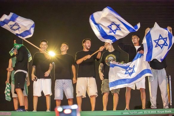 המונים הגיעו לחגוג את שובו של מתן אנגרסט לביתו בקריית ביאליק לאחר שיחרורו ממחילות החמאס בעזה 23.10.2025
בתמונה - אוהדי מכבי חיפה עומדים על תחנת אוטובוס